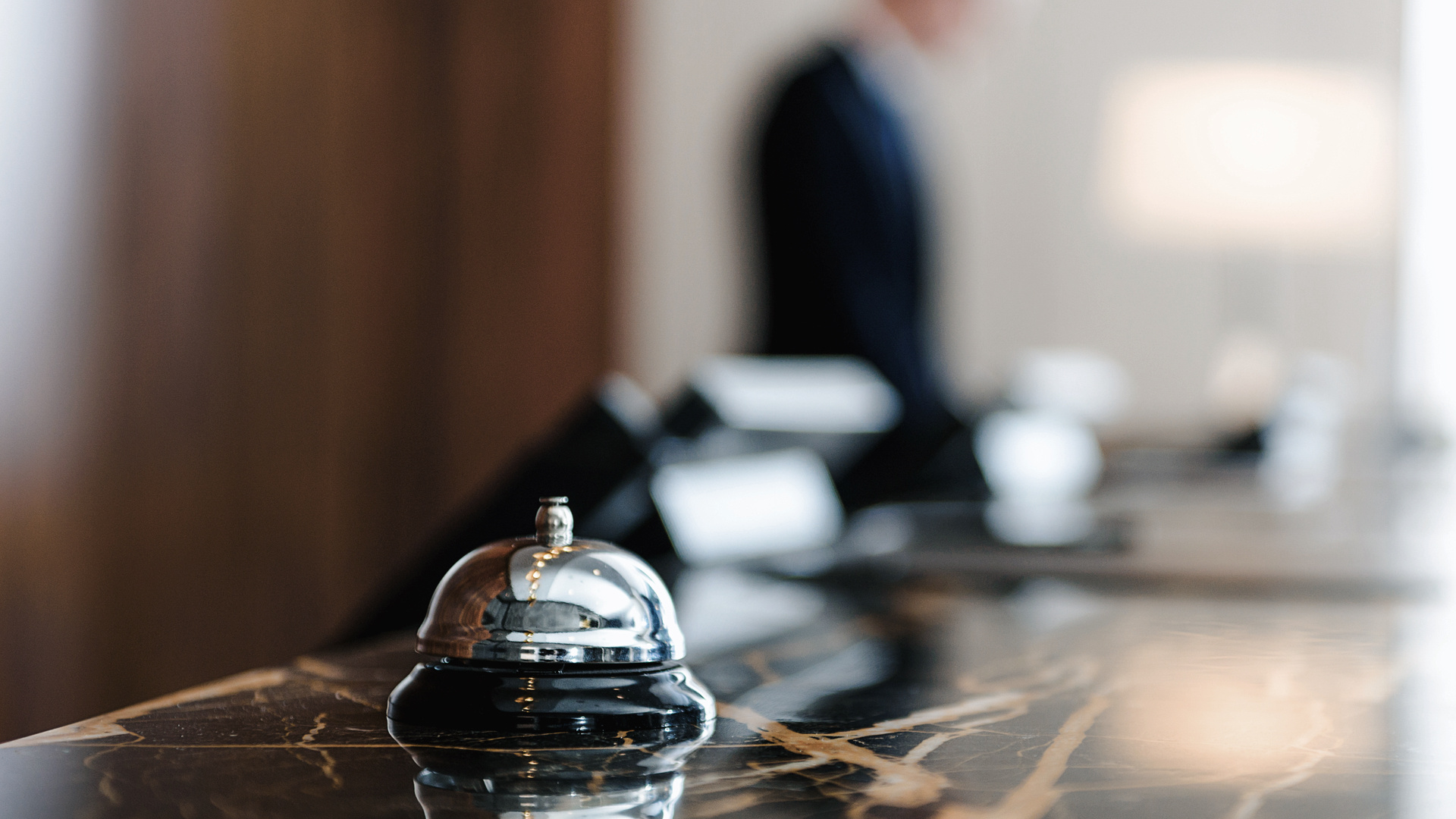 Silver hotel bell at the reception desk